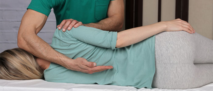 A chiropractor checking a woman's spinal alignement